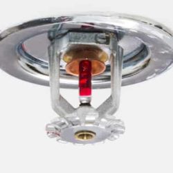 Close up image of fire sprinkler on white. Fire sprinklers are part of an integrated water piping system designed for life and fire safety.